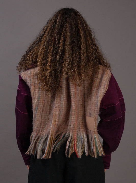 Person wearing a purple jacket with a plain background