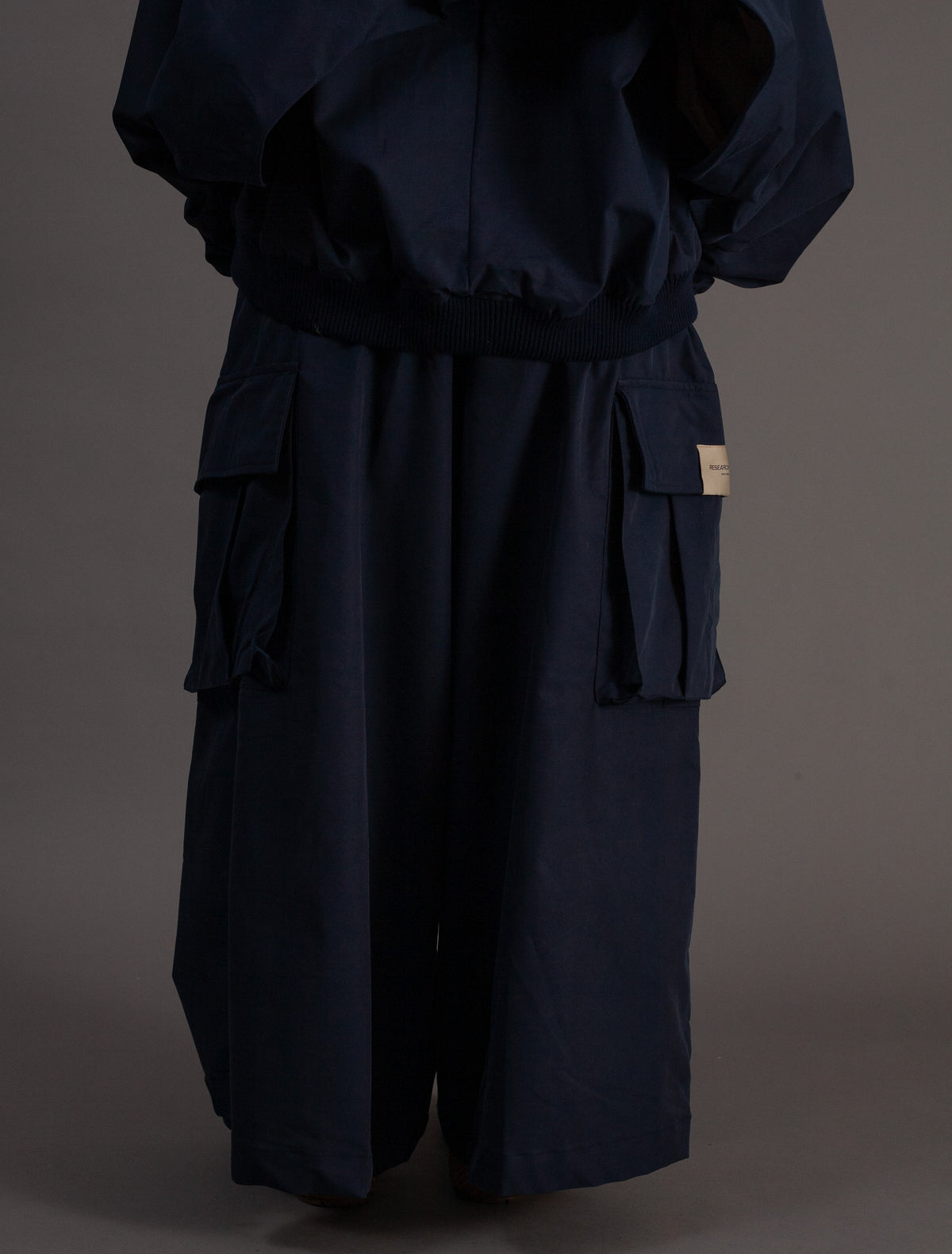 Navy blue outfit with wide-leg pants on a dark background