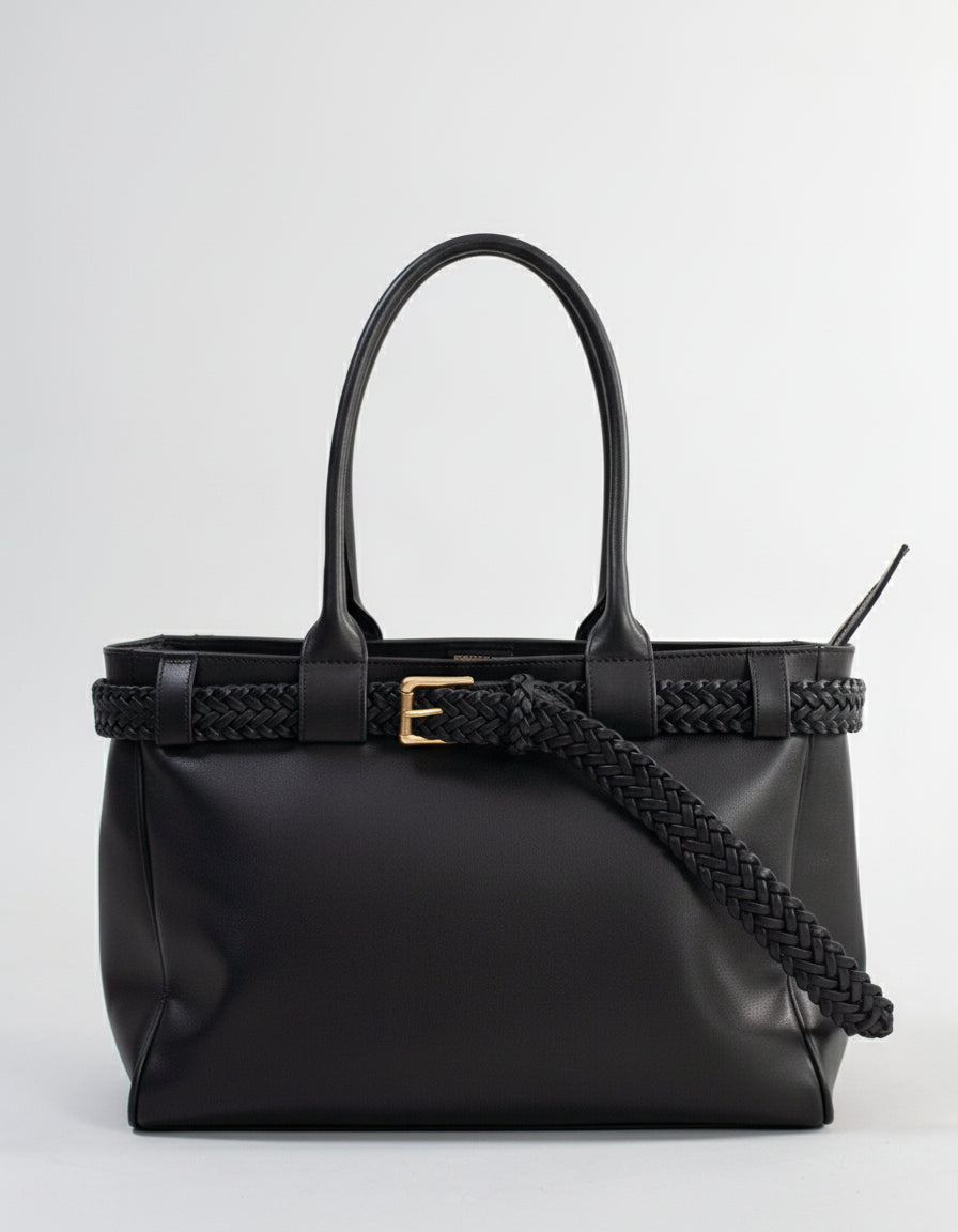 Black handbag with braided handle on a grey background