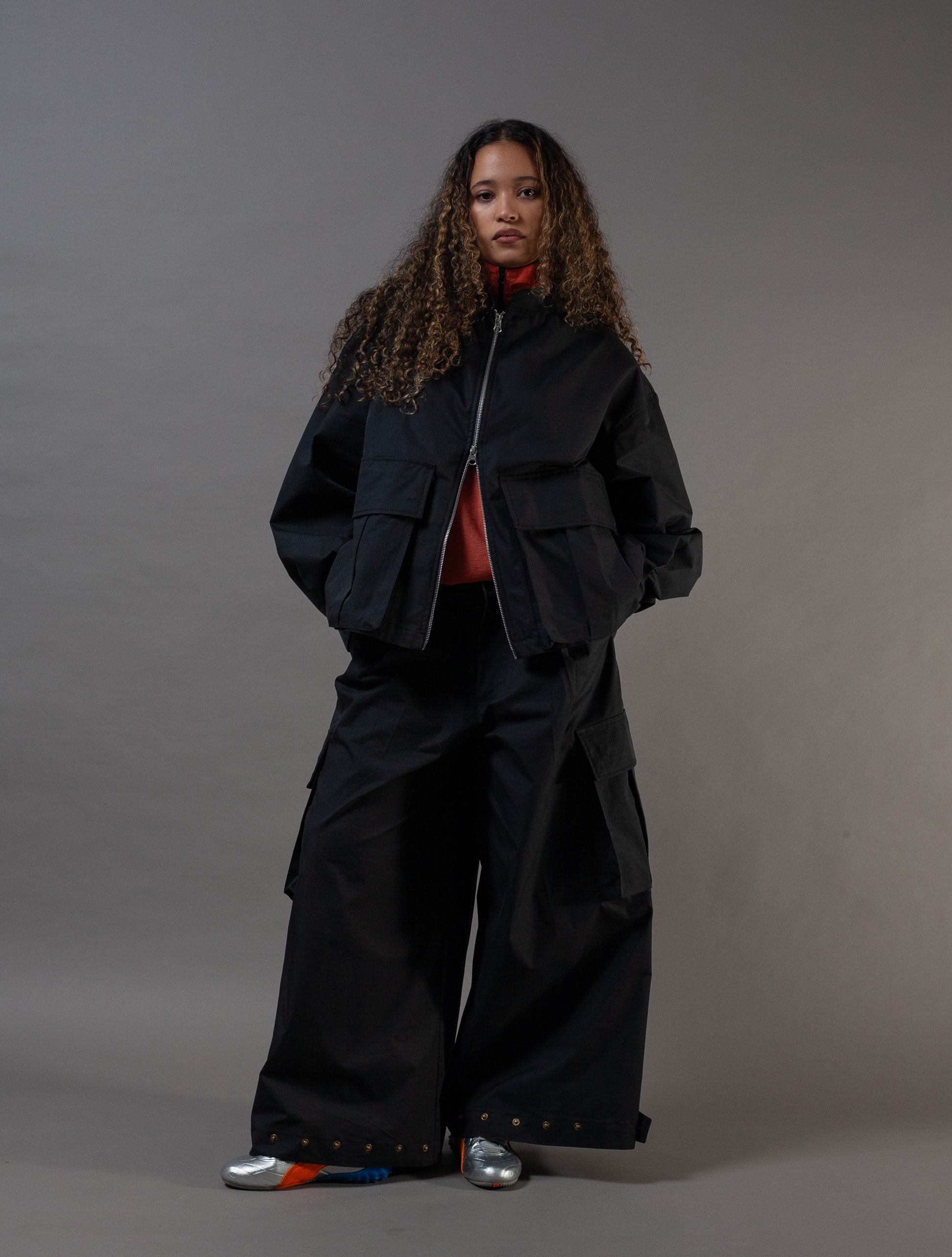 Person wearing a black outfit with a gray background