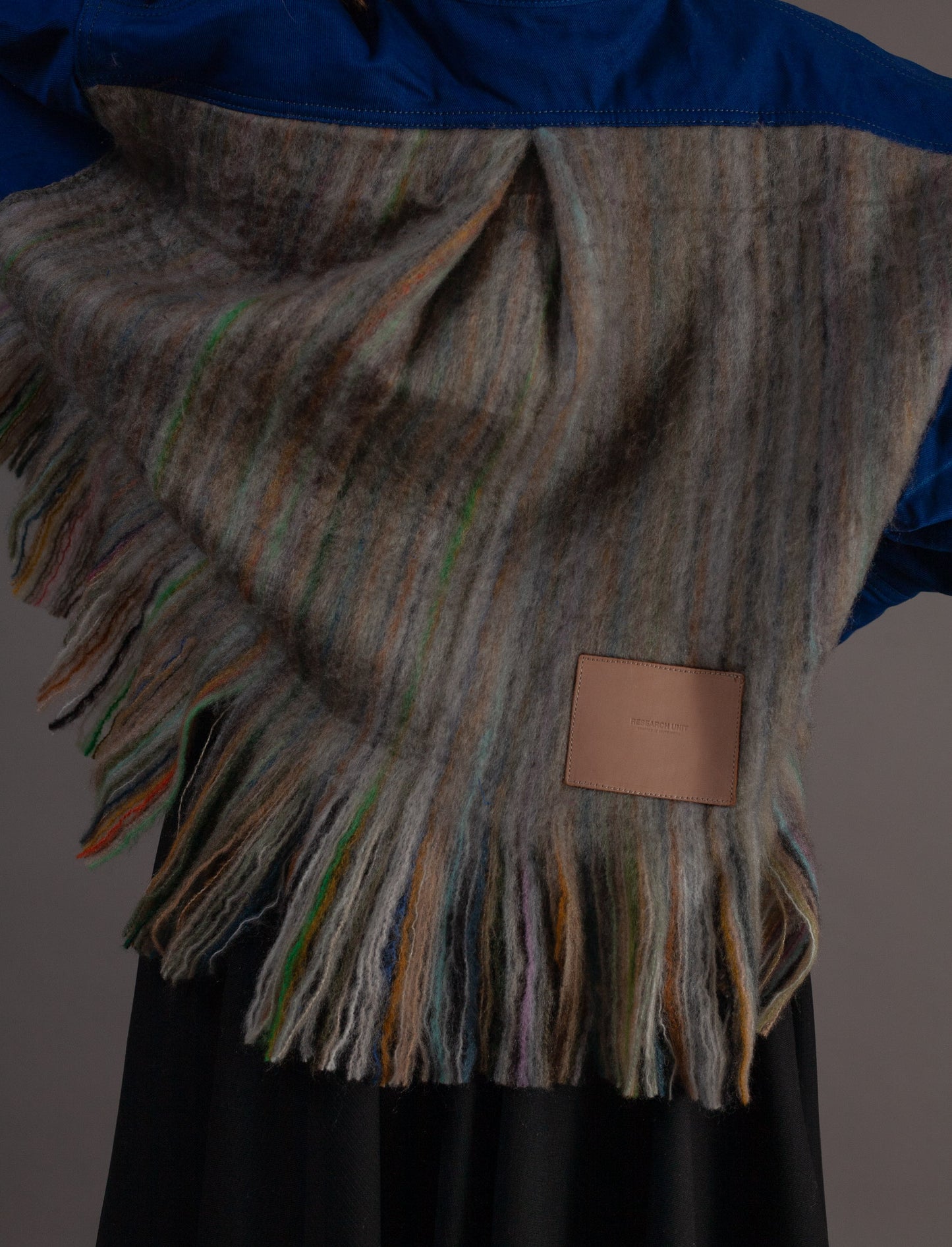 Woven blanket with fringes on a plain background