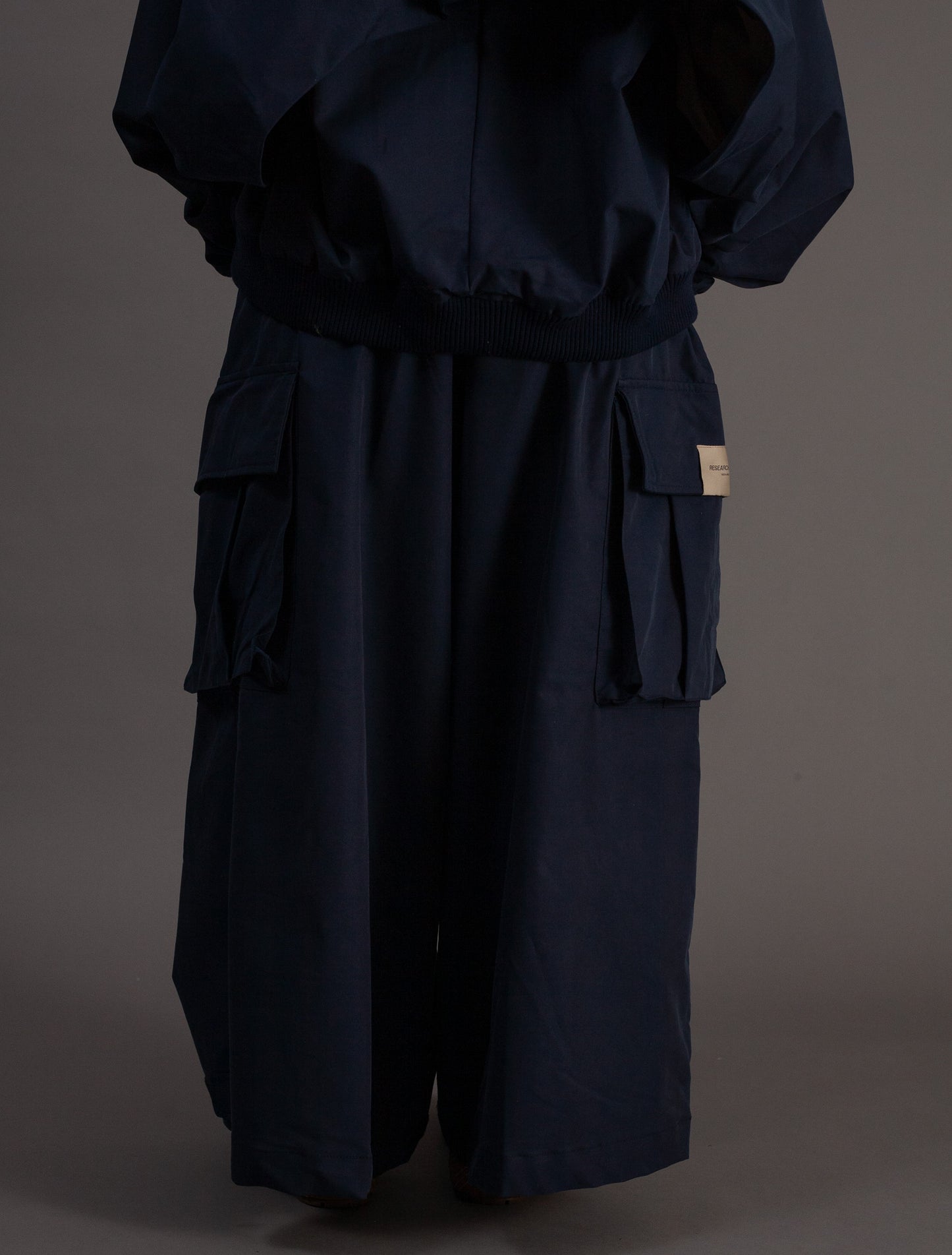 Navy blue outfit with wide-leg pants on a dark background