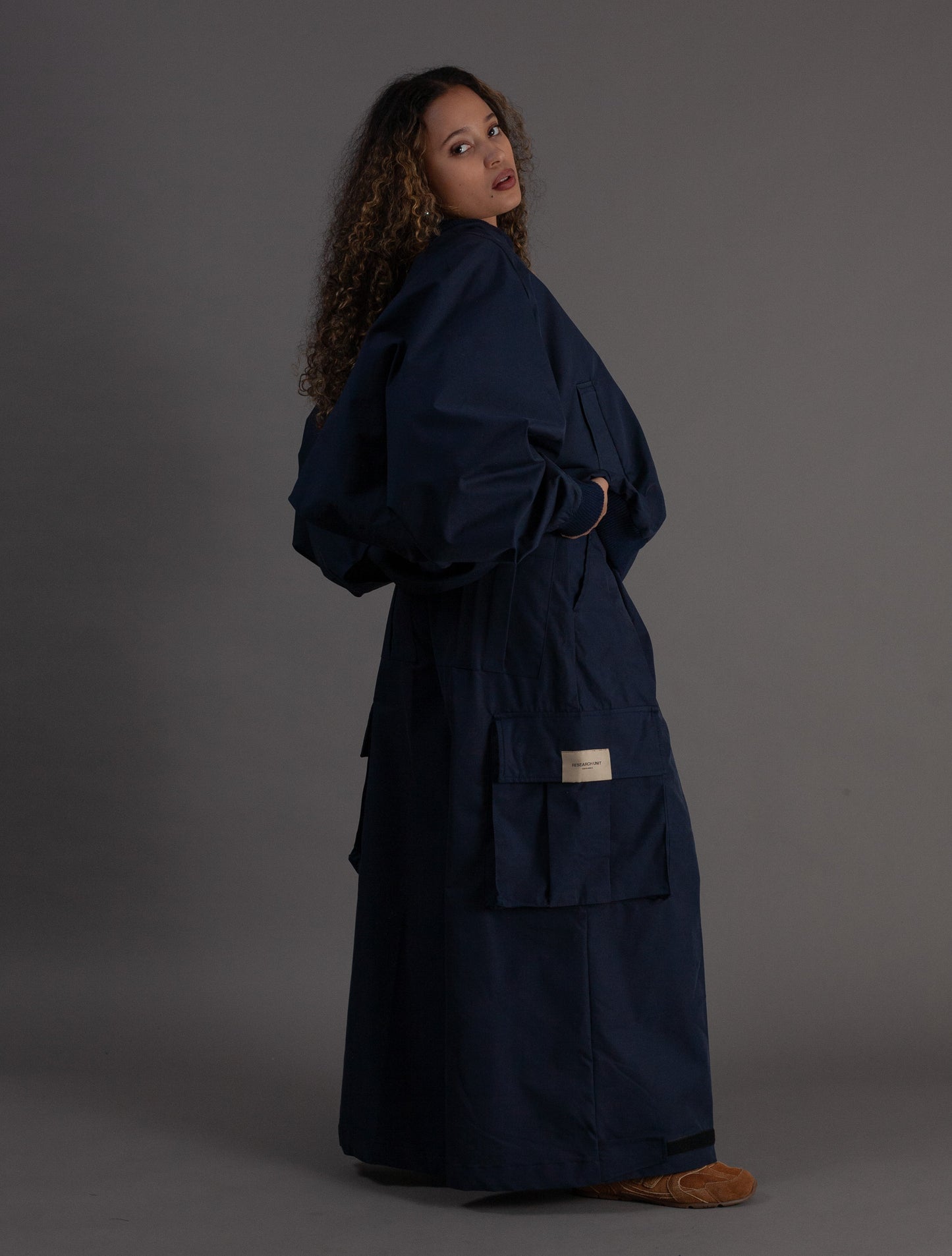Woman wearing a navy outfit against a gray background