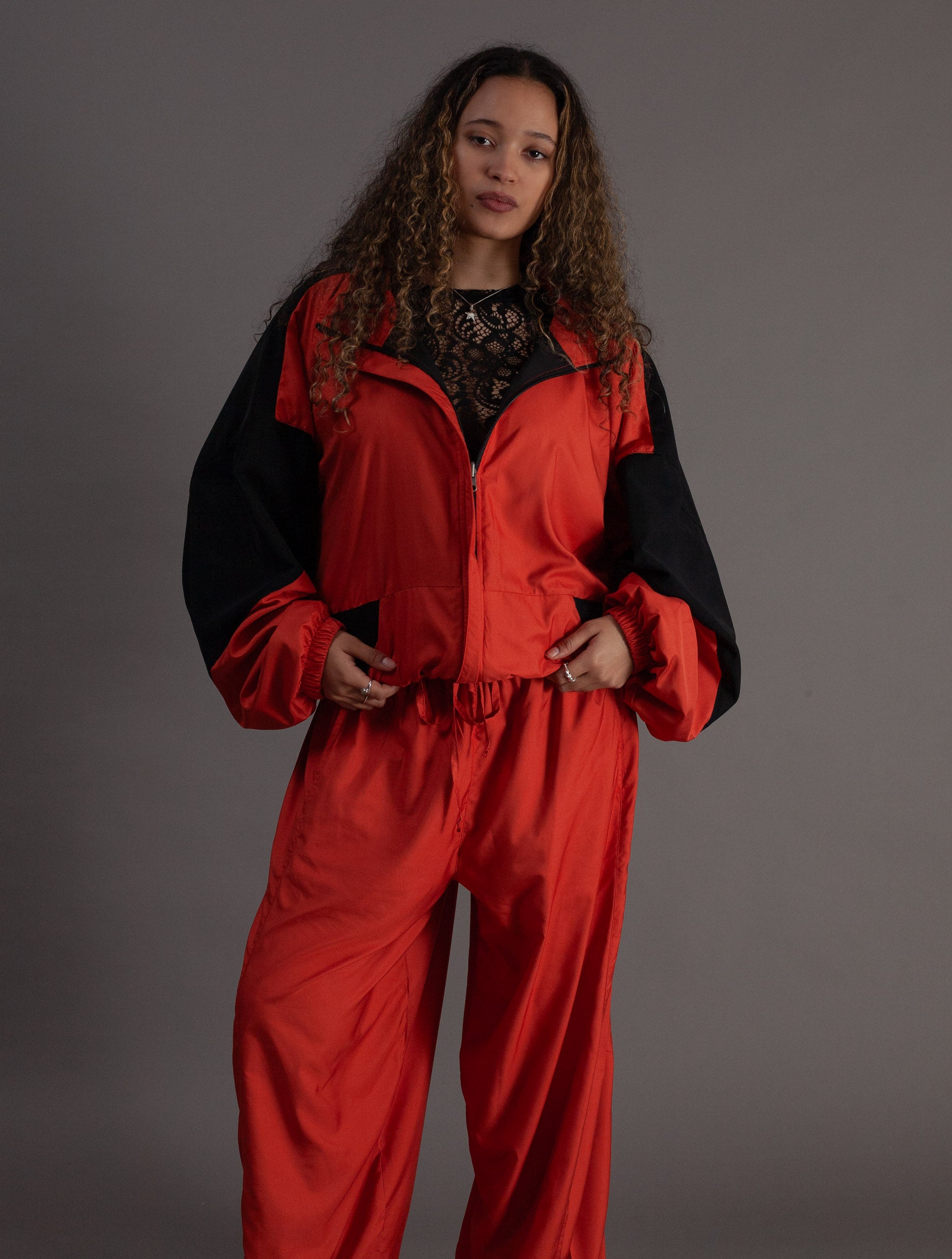 Person wearing a orange and black jacket against a gray background