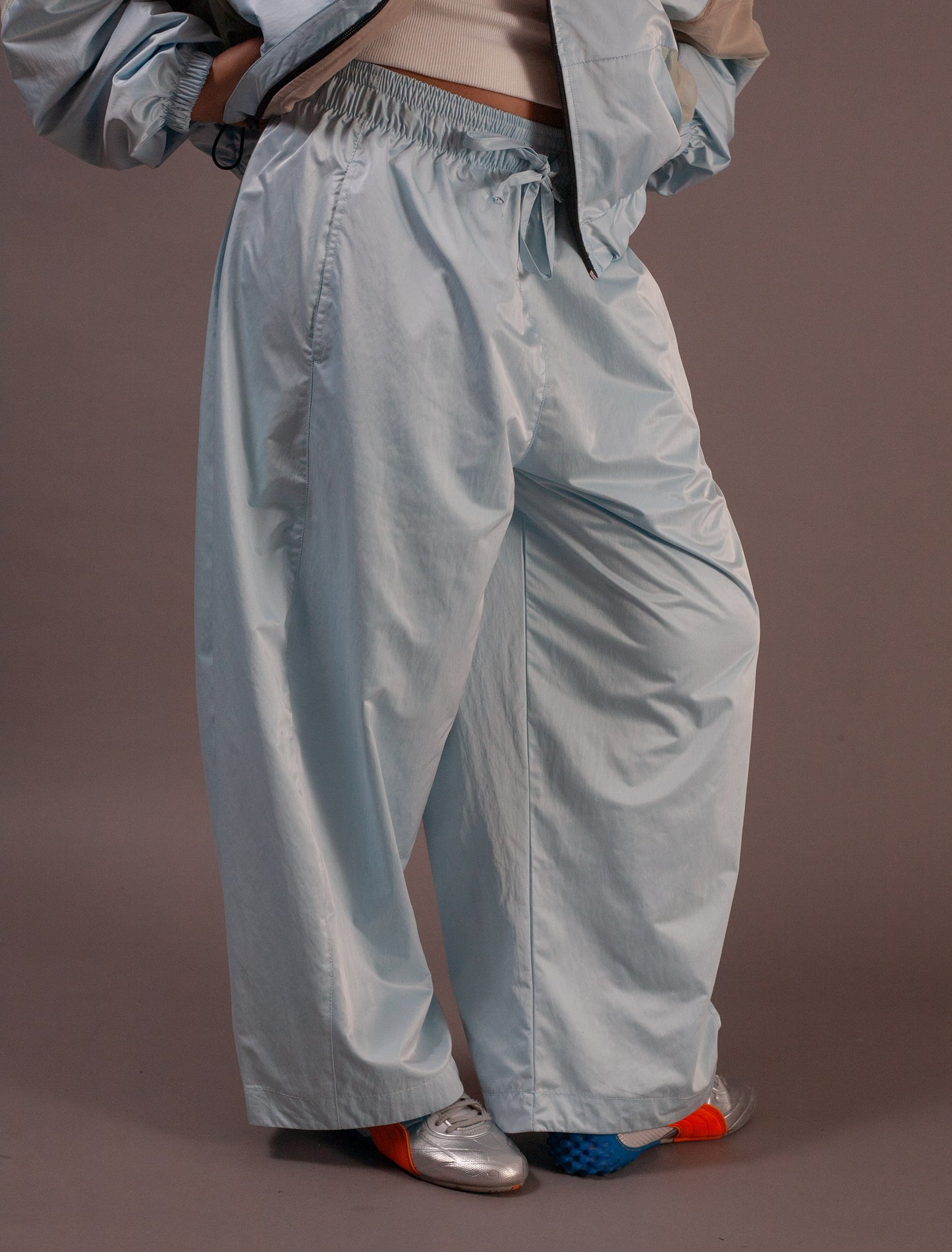 Light blue pants worn by a person on a brown background