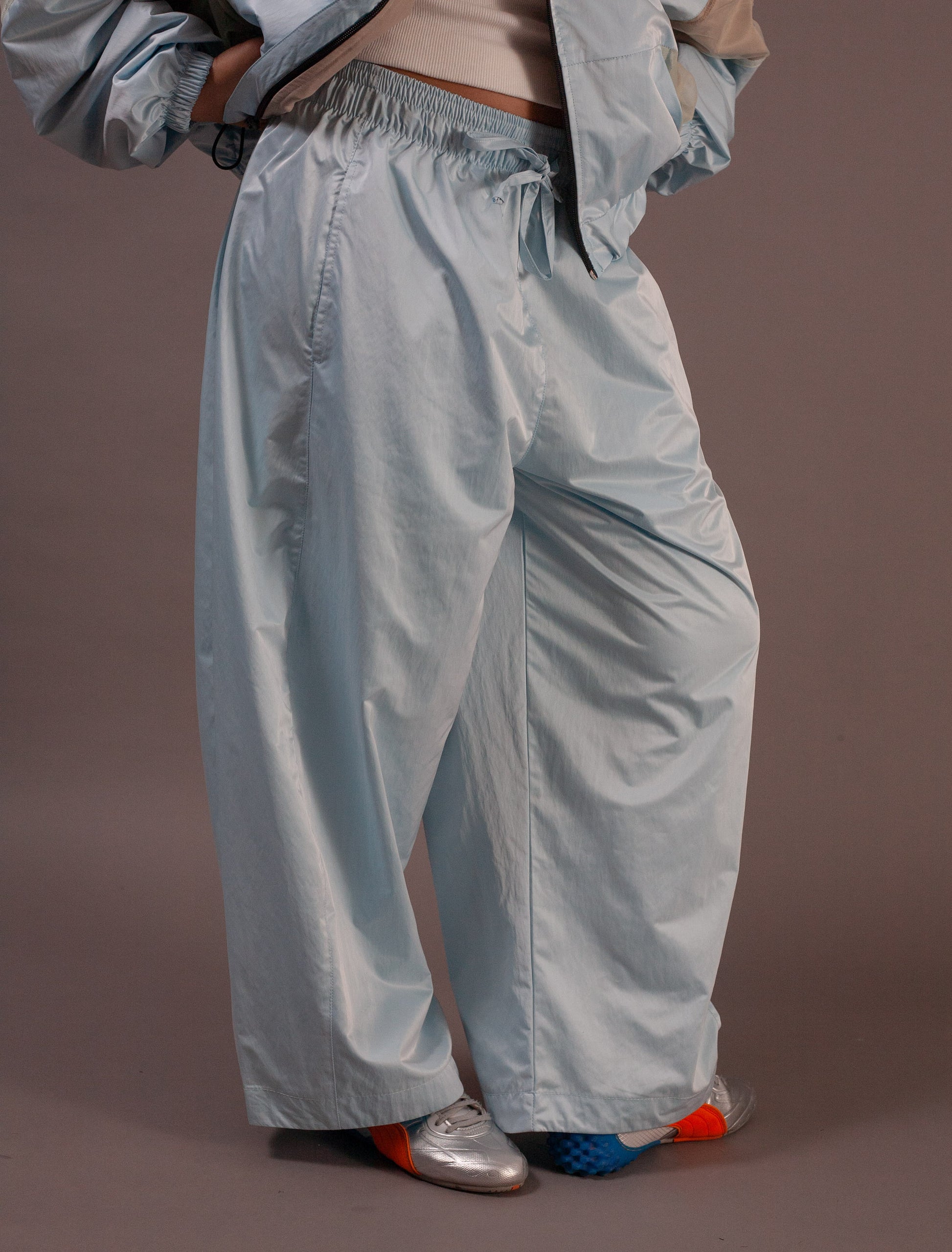 Light blue pants worn by a person on a brown background