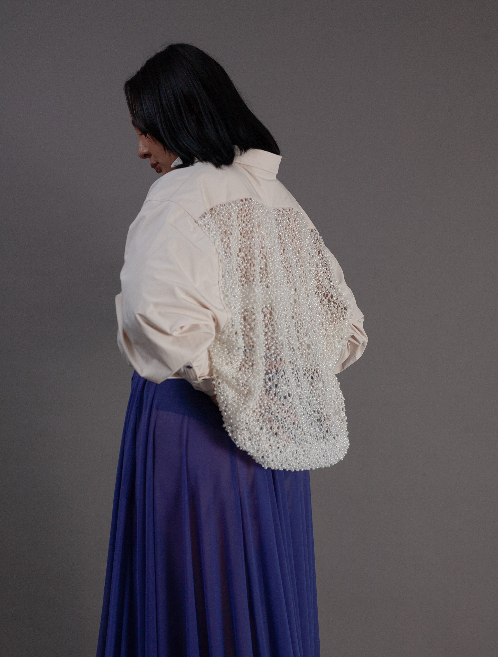 Person wearing a white pearl back detail  top 