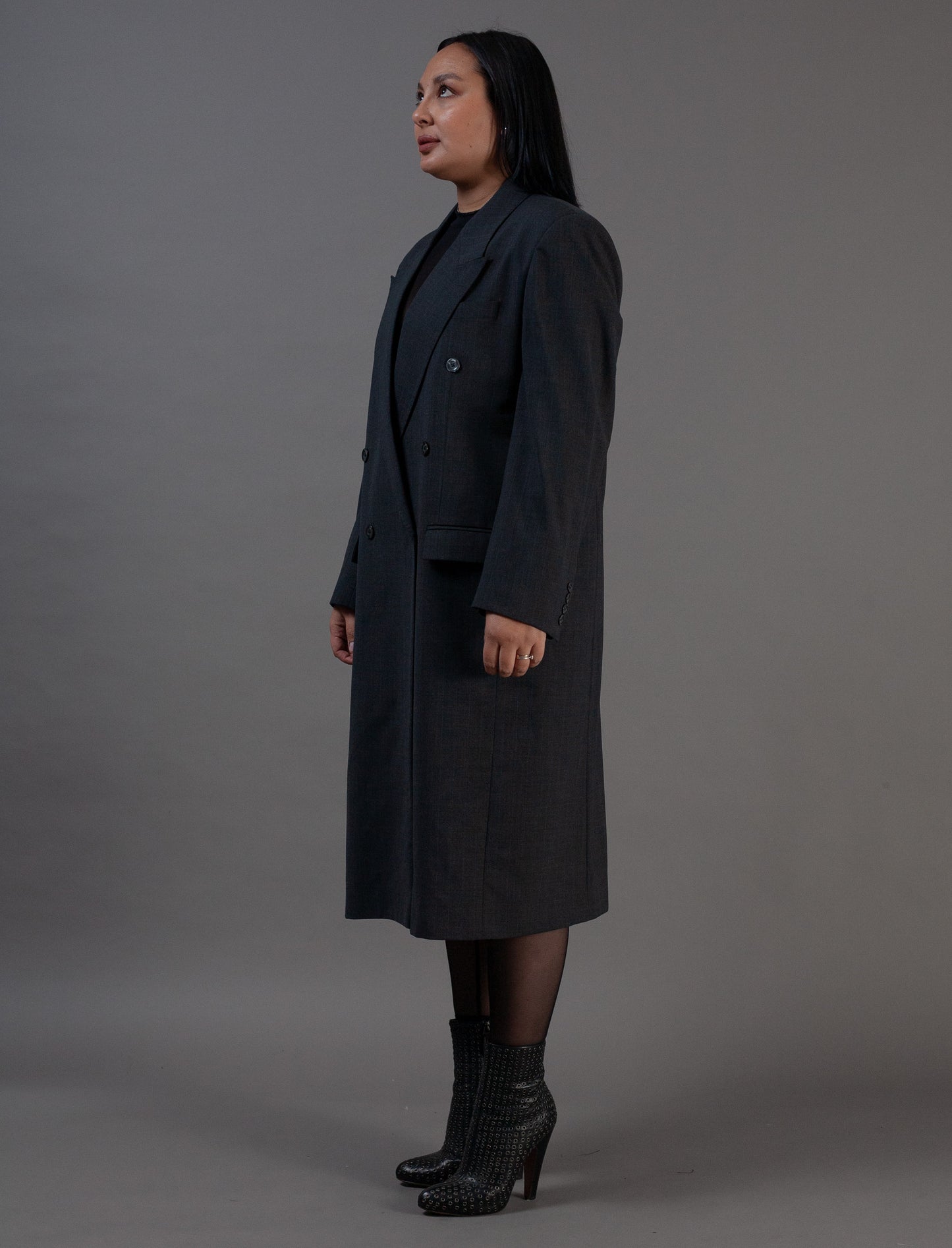 Woman wearing a long grey pinstripe dark coat 