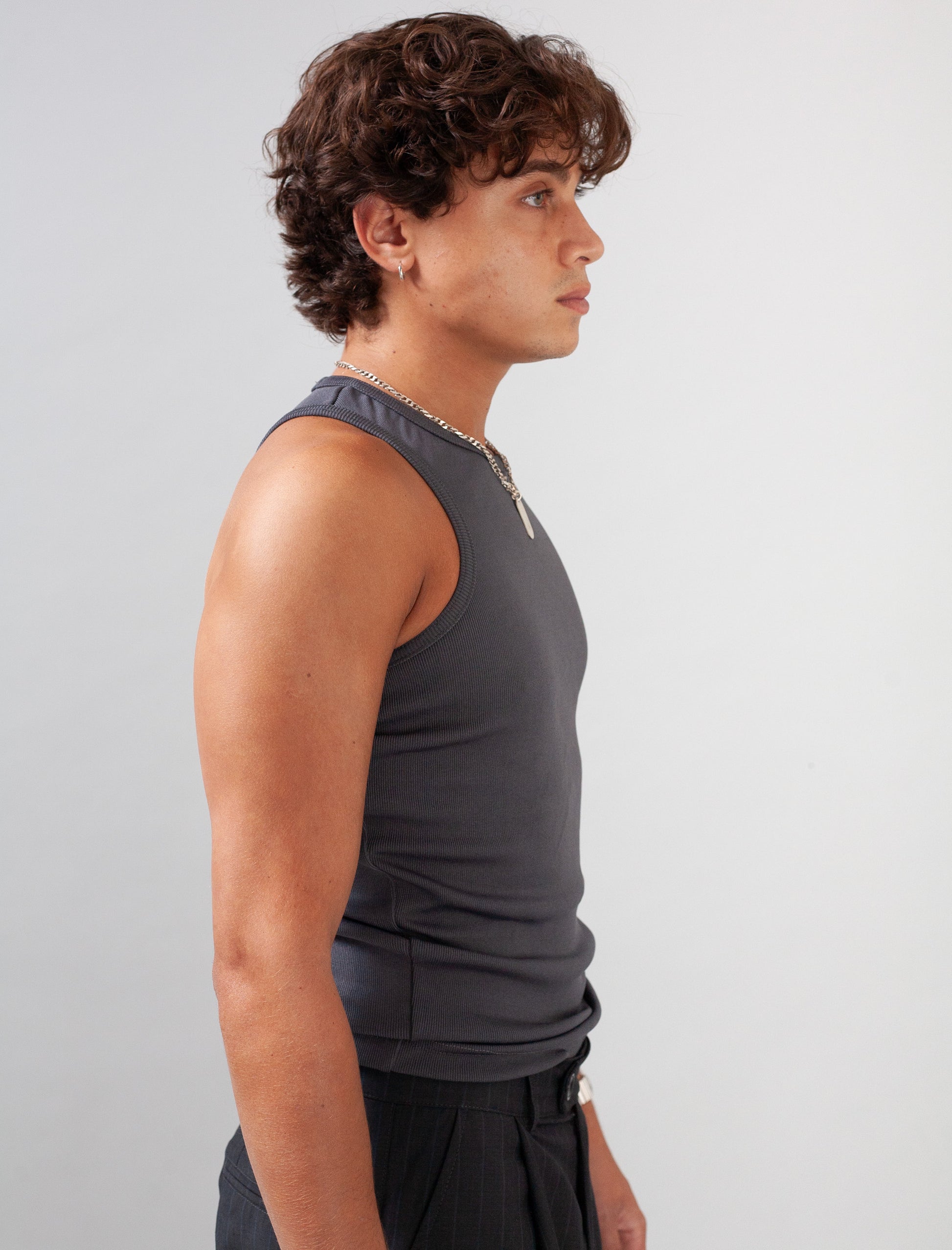 Person wearing a gray tank top against a plain background