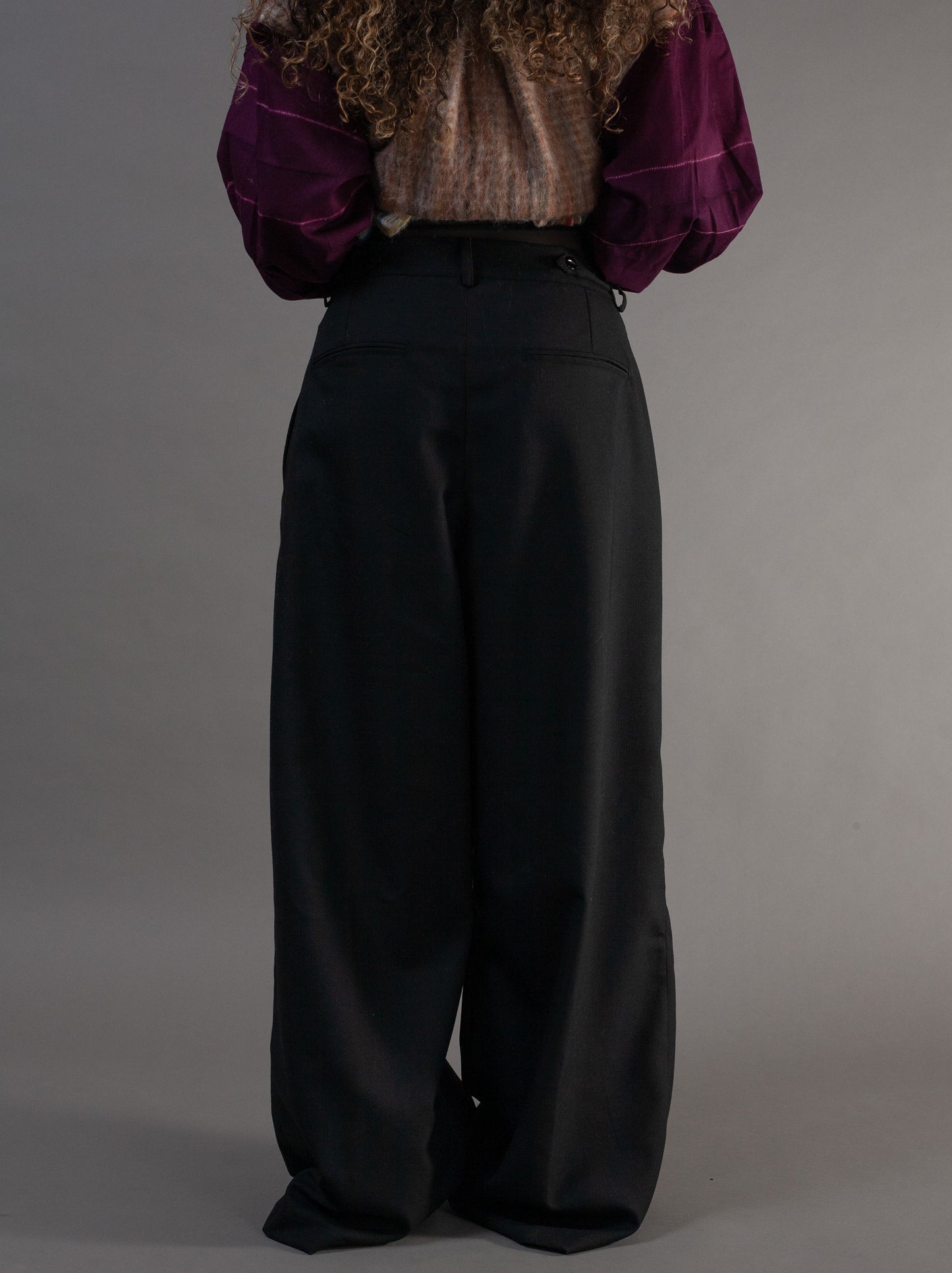 Person wearing a purple blouse and black adjustable wide-leg pants 