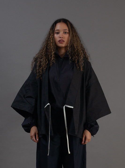 Person wearing a black kimono with white drawstrings 
