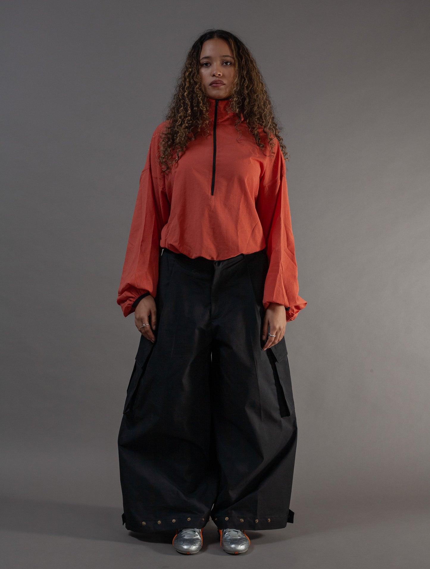 Woman wearing an orange top and black pants 