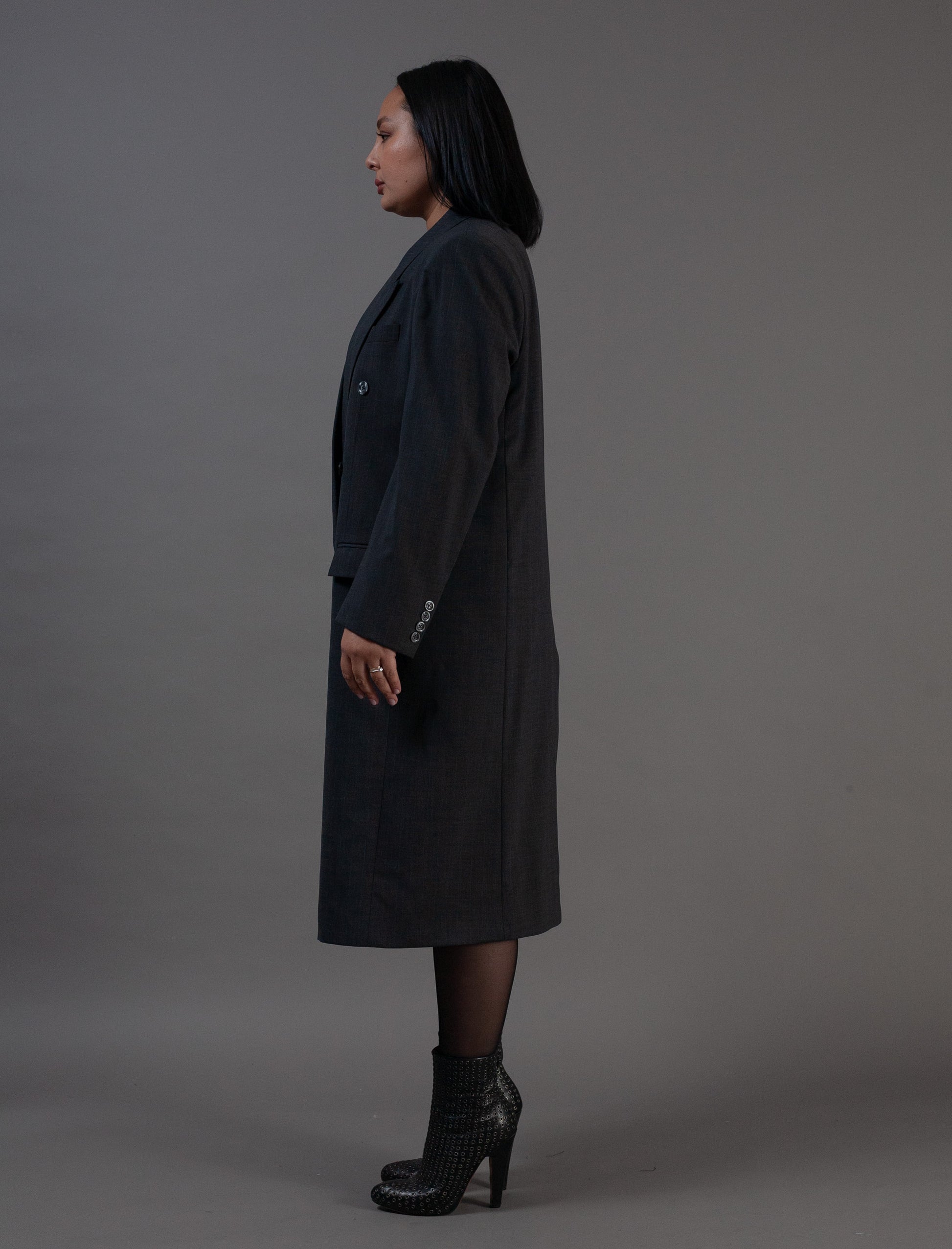 Woman wearing a long grey pinstripe dark coat 
