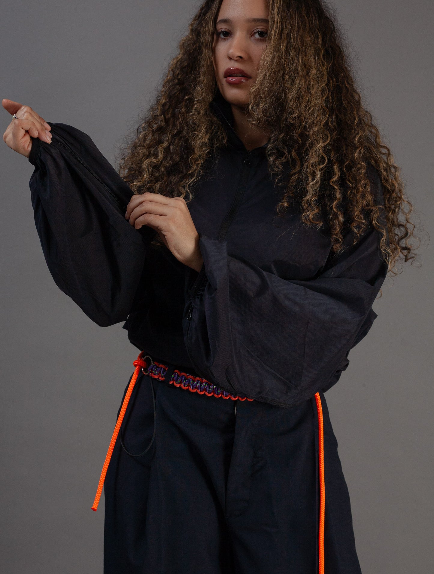 Person wearing a black outfit with orange accents